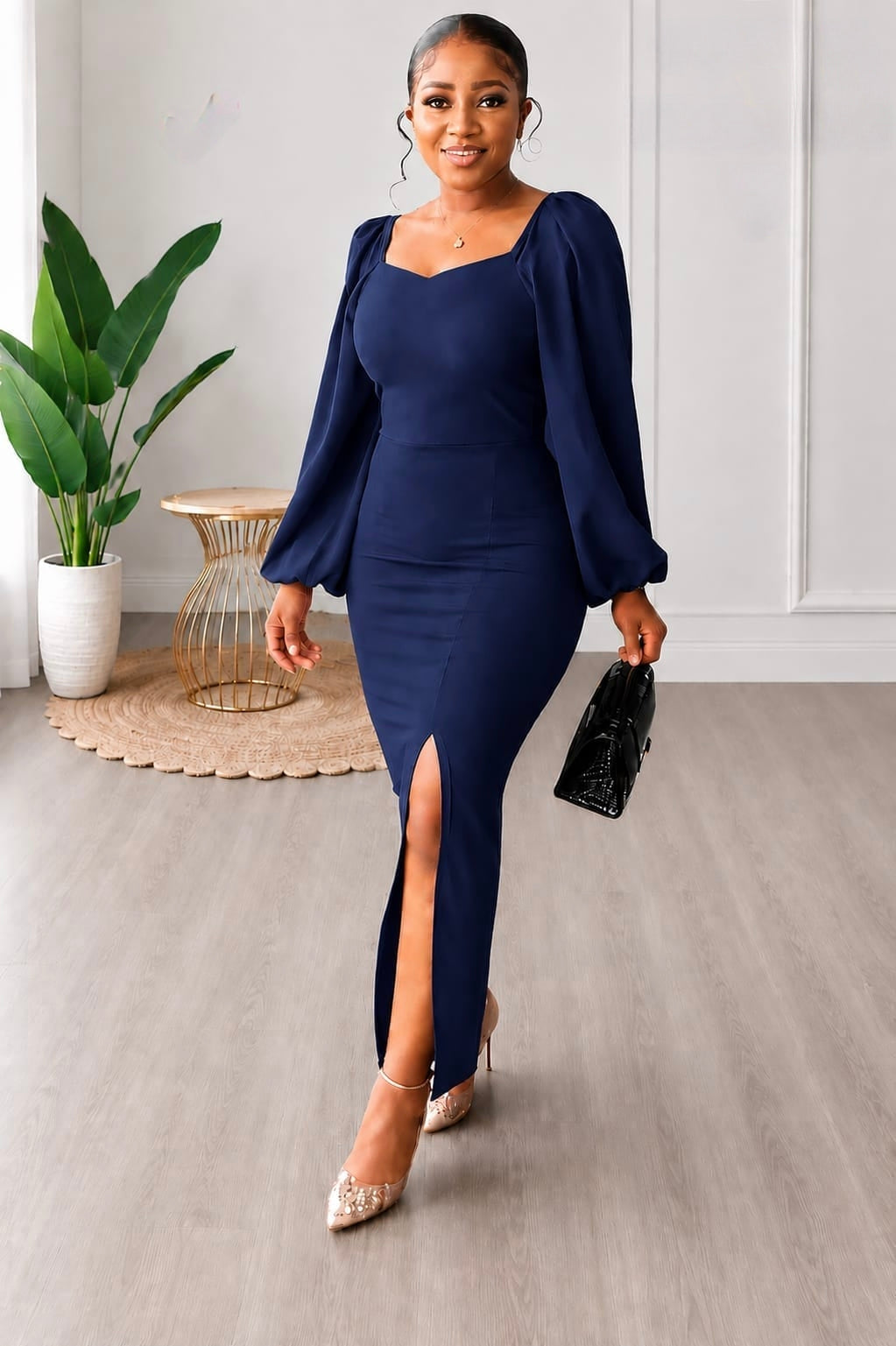 Navy blue elegant puff-sleeve slit maxi dress with sweetheart neckline, styled with high heels and a handbag.