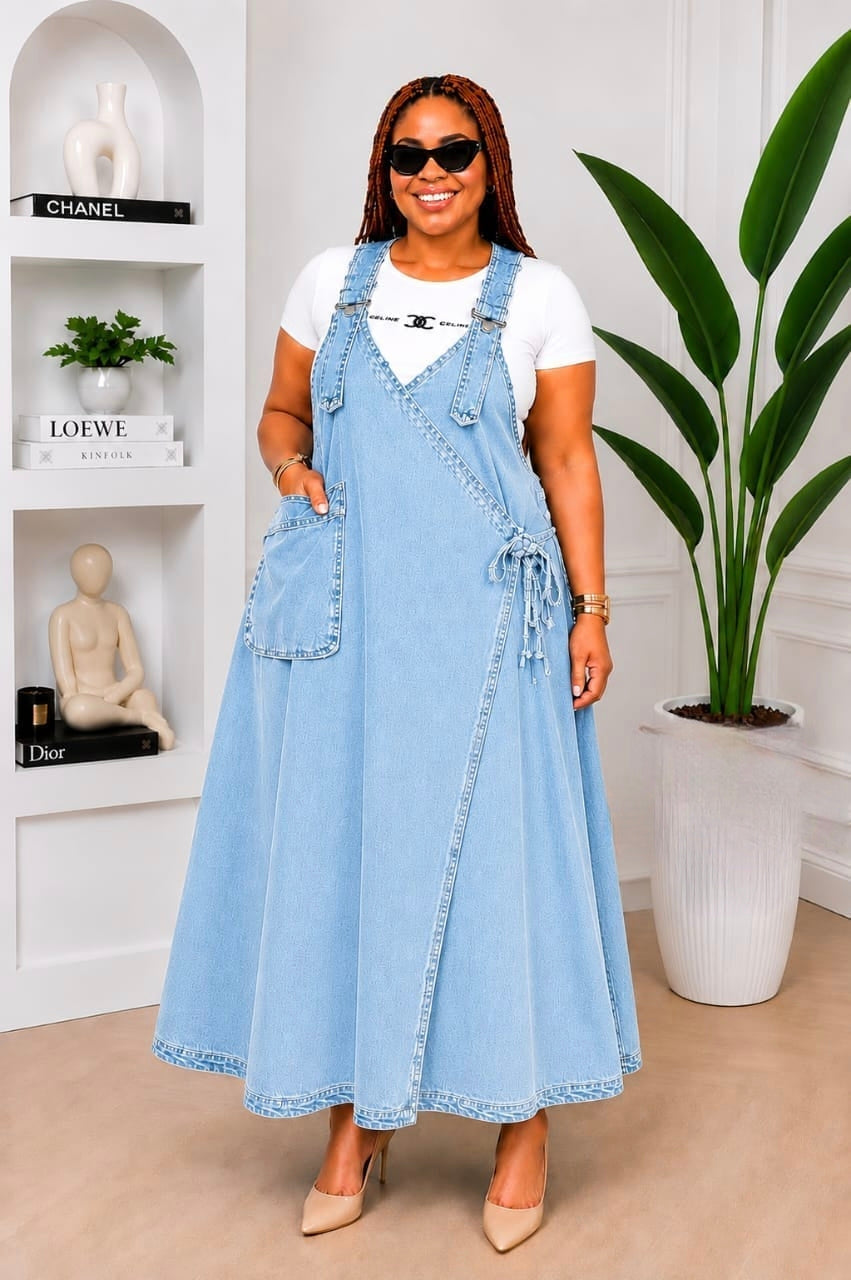 Denim wrap overall maxi dress with wide adjustable straps, large patch pocket, and A-line silhouette, styled with a fitted tee.