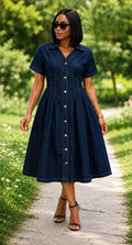 Button-front midi dress with structured bodice, flared skirt, classic collar, and short sleeves in an outdoor setting.