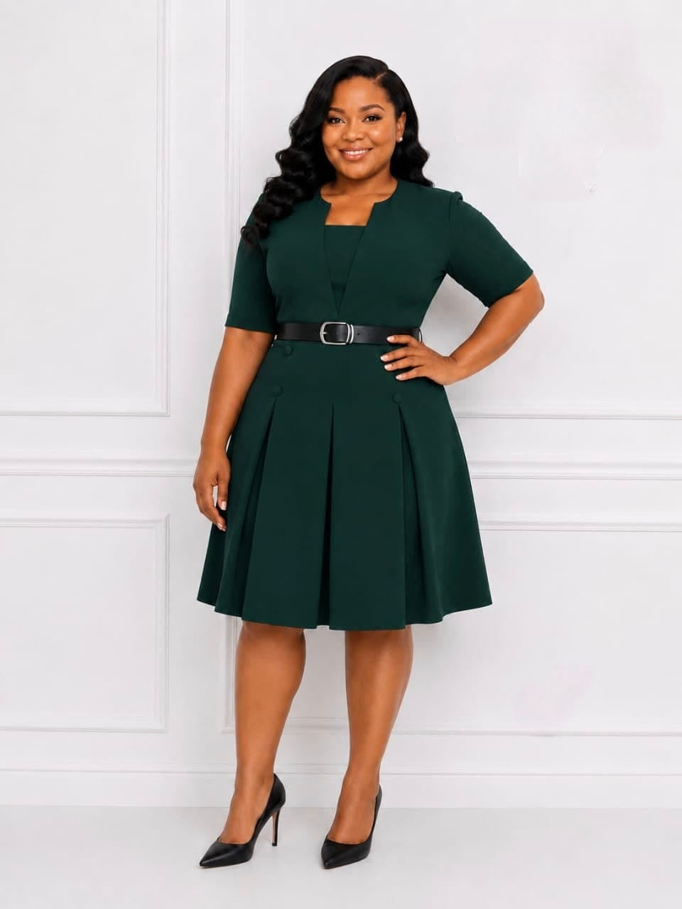Dark green pleated midi dress with a structured bodice, short sleeves, and a metallic buckle belt at the waist.