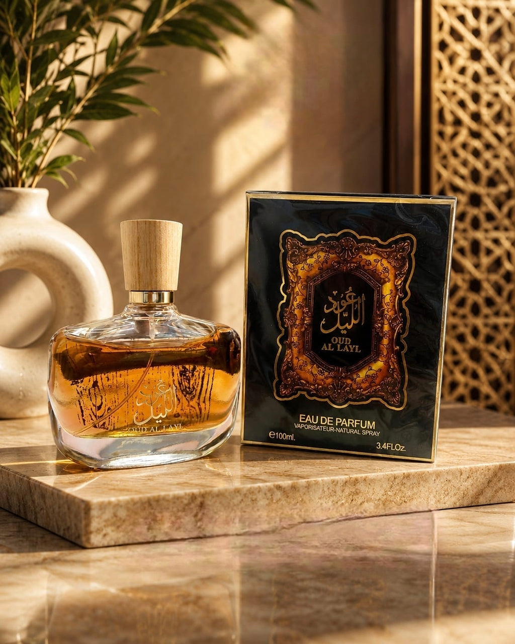 Clear bottle of Oud Al Layl Eau de Parfum with a wooden cap next to an ornate box featuring the product name.