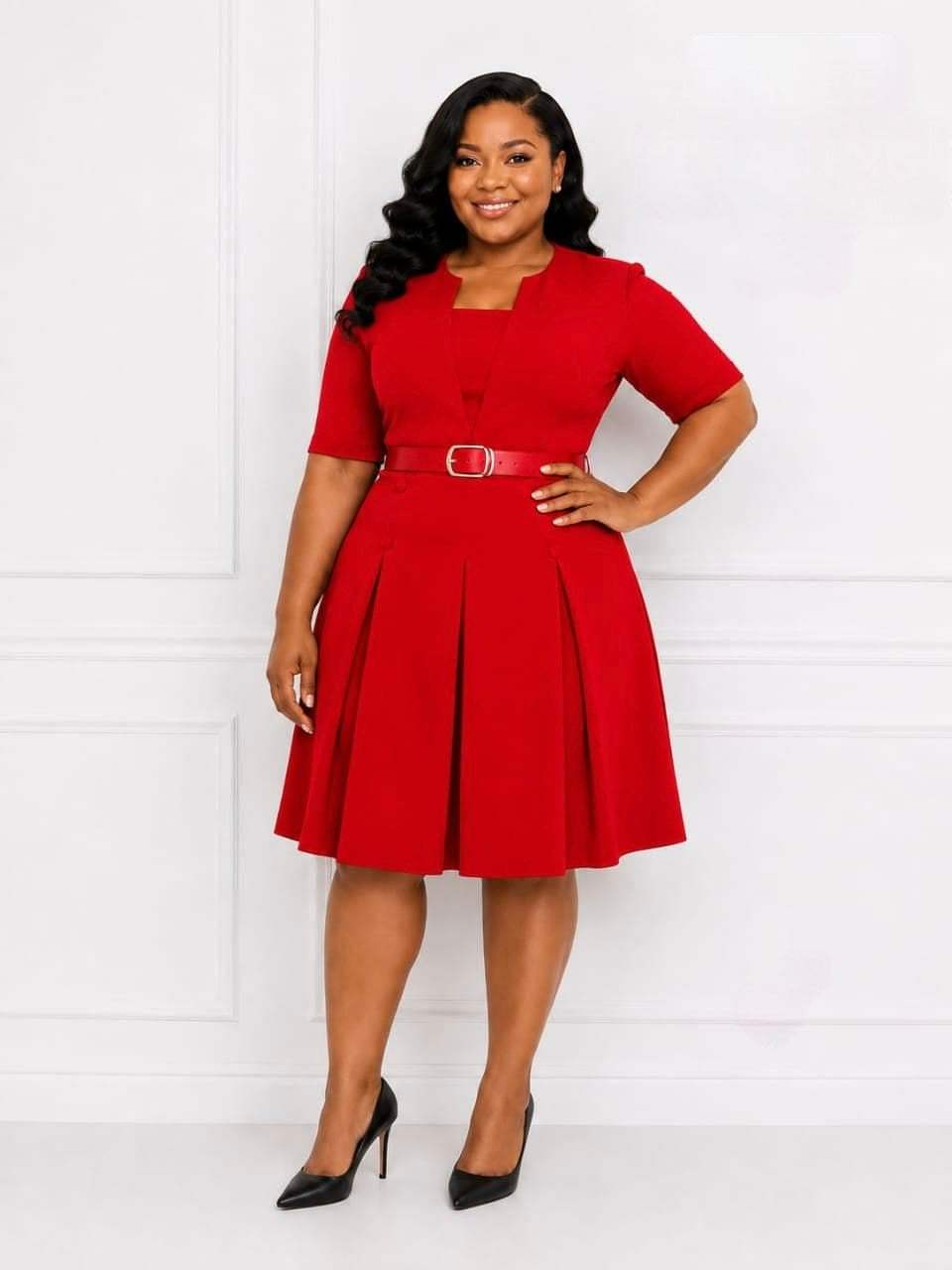 Red pleated midi dress with a structured bodice, short sleeves, and a metallic buckle belt, styled with black high heels.