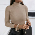 Fitted ribbed turtleneck sweater in warm beige, styled with black faux-leather pants for a sophisticated look.