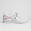 Light grey suede Nike Air Force 1 Low with hot pink and white Supreme box logo and white bottle-cap keychain | Ovadue