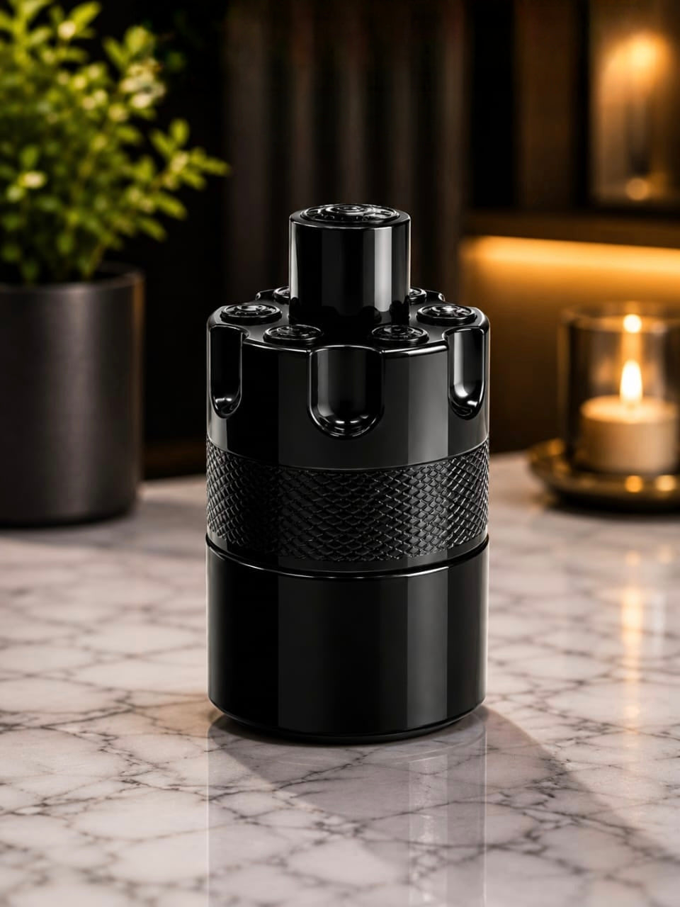 Black bottle of The Most Wanted eau de Parfum by Ovadue on a marble surface with a plant and candle in the background.