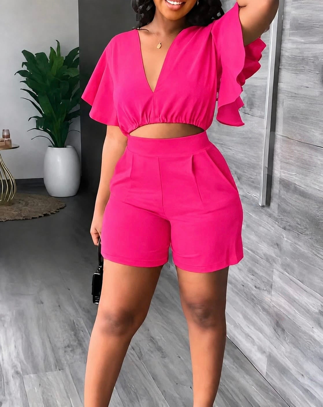 Flutter sleeve crop top with deep V-neck and midriff cutout paired with high-waisted shorts featuring front pleats.