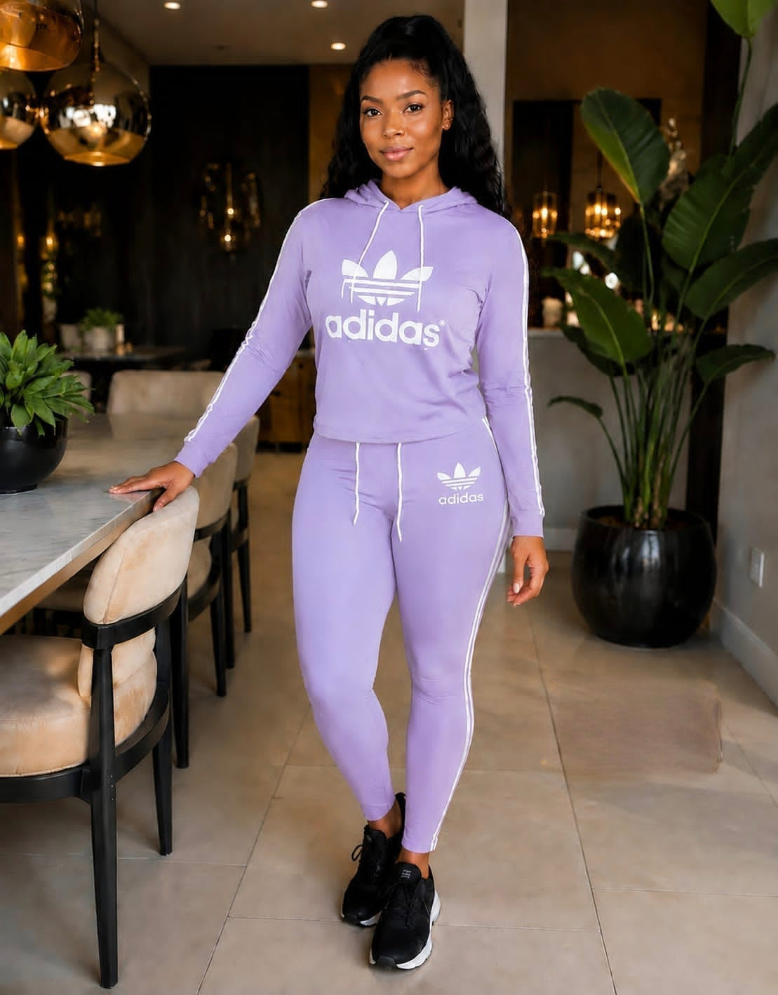 Light purple Adidas Tracksuit Set KT featuring a drawstring hoodie and joggers with side stripes, styled with black sneakers.